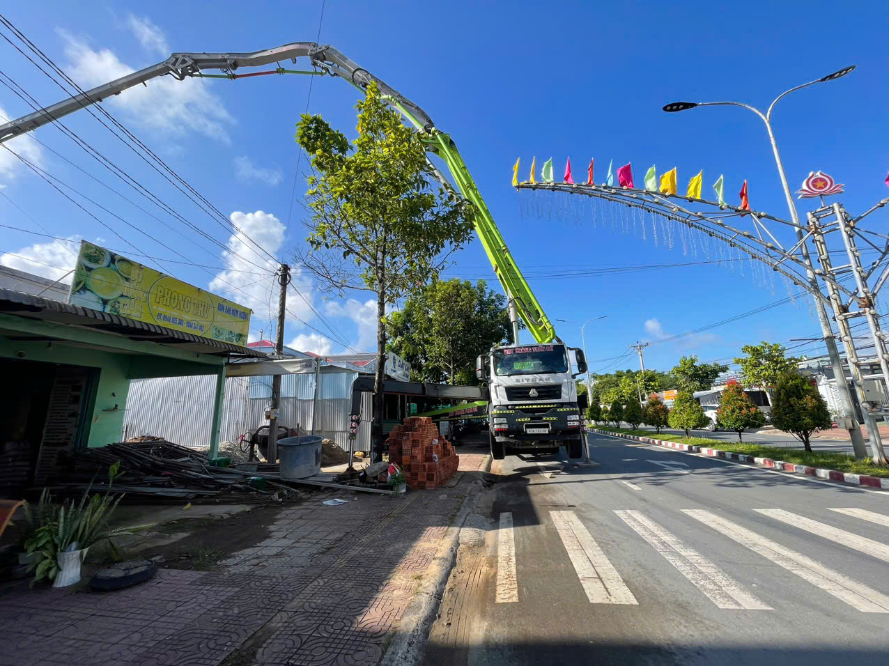 Xe bơm bê tông Huy Hoàng Trần Đề thi công trên tuyến đường tại Trần Đề, Cần Thơ